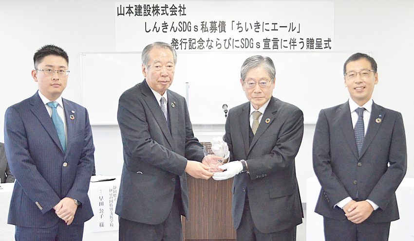 平井理事長（左から3人目）が山本建設の山本良一代表取締役（同2人目）に記念の盾を手渡した（11月29日、静岡県立伊豆の国特別支援学校、提供）